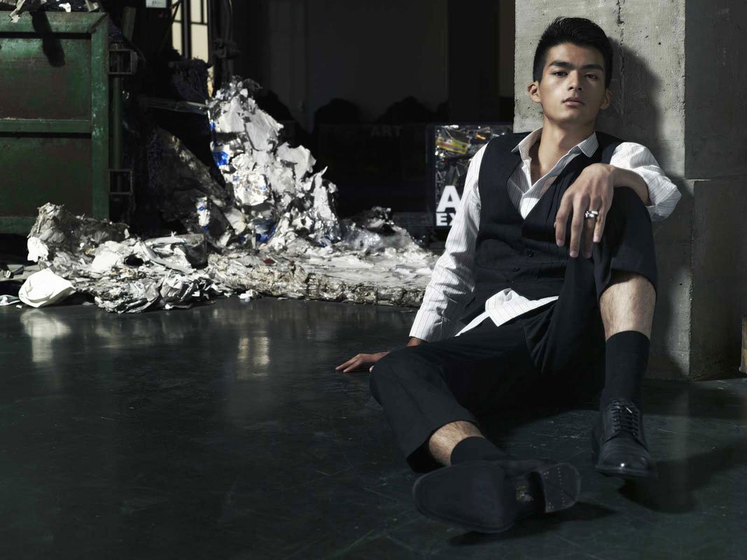 Men's campaign portrait seated in an industrial warehouse