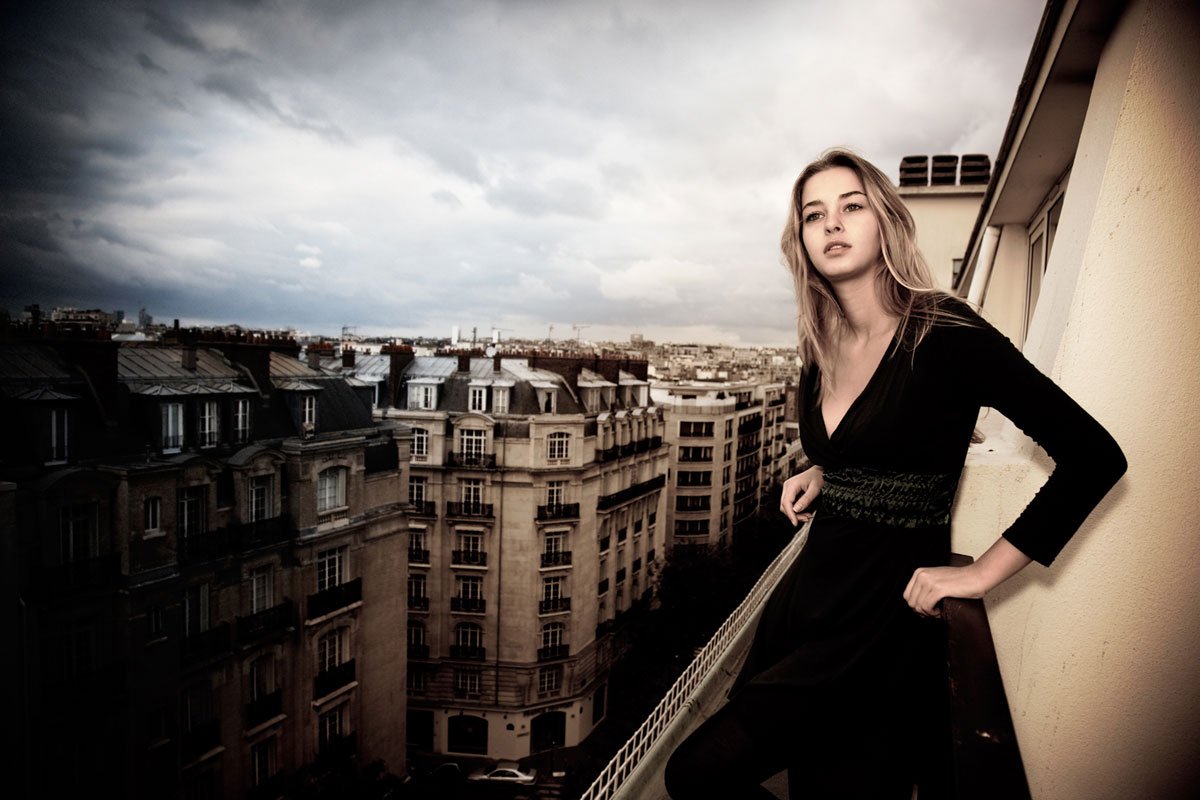Portrait on a balcony over the Paris skyline