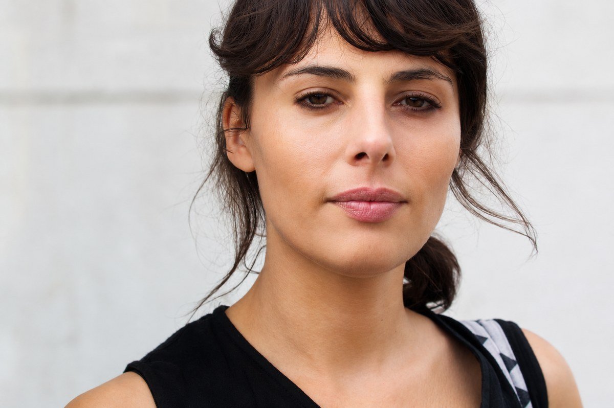 Close-up portrait against a concrete wall