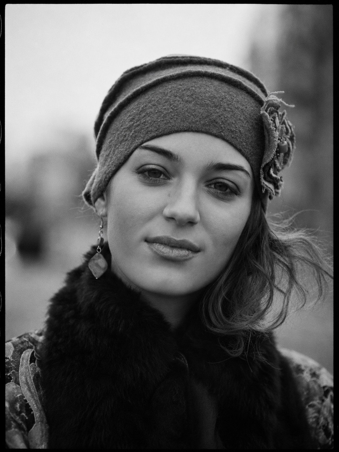 Black and white portrait in a knit hat and fur collar